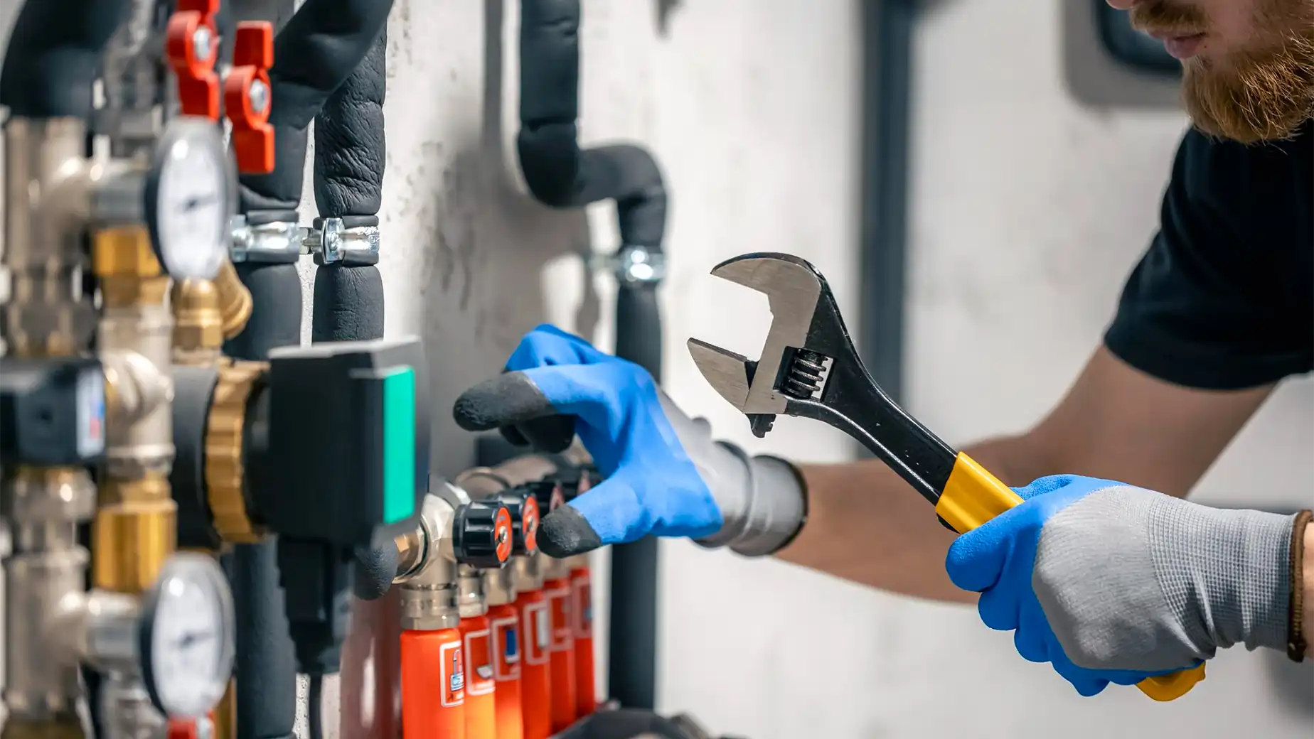 Mężczyzna regulujący instalację centralnego ogrzewania wyposażoną w piec na pellet